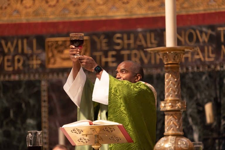 Trinity_0924-360 priest lifts high the communion cup