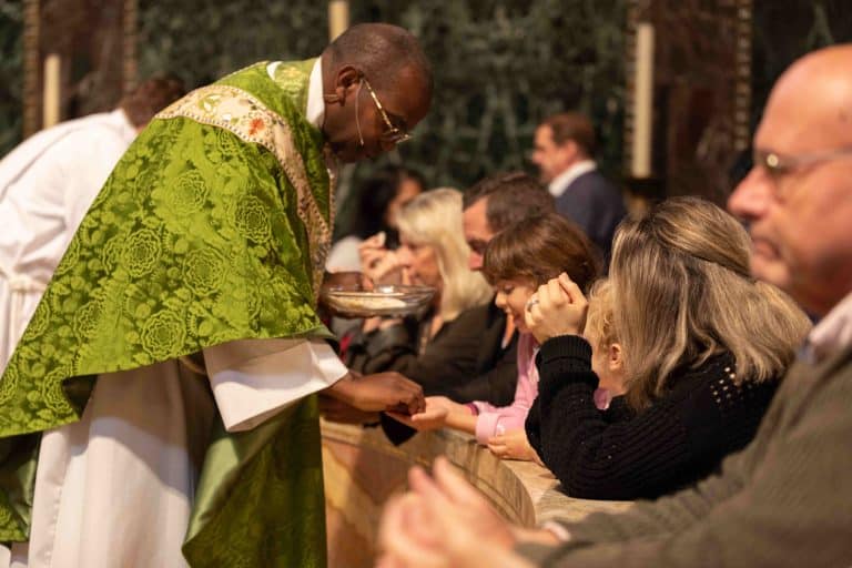 Trinity 0924 415 Priest In Green Robe Gives Eucharist To Delighted Child In Pink
